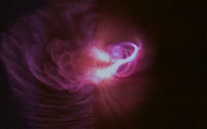 Pinkish-purple plasma swirls against the darkness of space.