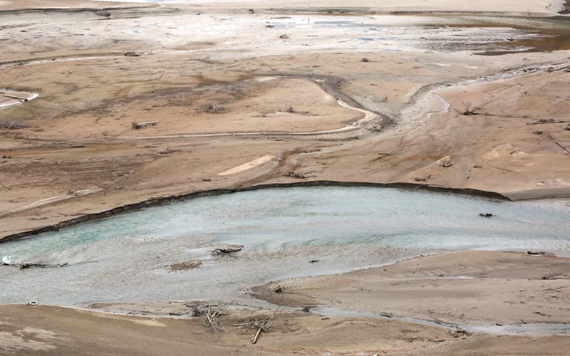 Rivulets of water erode the unstable surface of a mudflat.